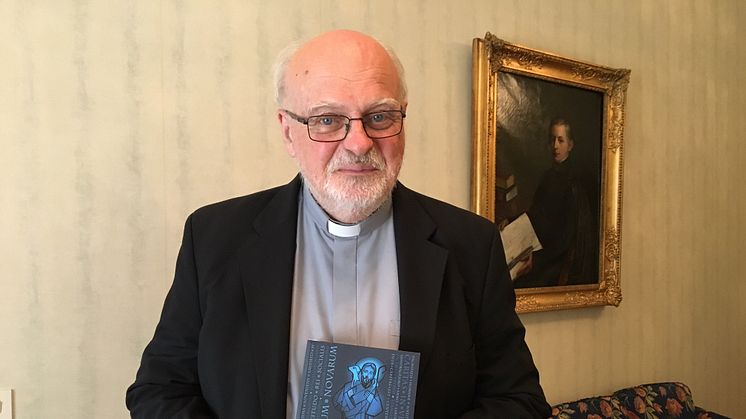 Kardinal Anders Arborelius med den katolska socialläran som nu finns i svensk översättning.