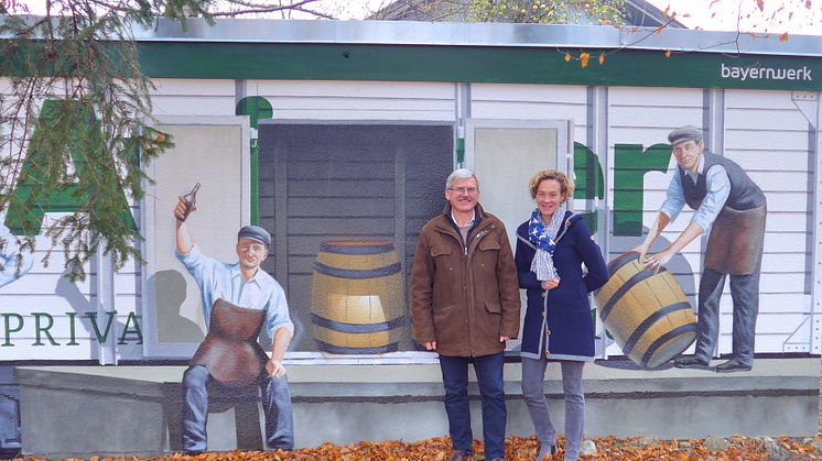 Ein weiteres Original aus Aying: Bürgermeister Johann Eichler (l.) und Bayernwerk-Kommunalbetreuerin Silke Mall (r.) stellen am Bahnhof die von ART-EFX zu einem historischen Güterwagon umgestaltete Trafostation der Öffentlichkeit vor.