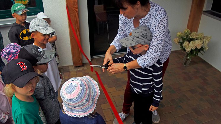 Kitaleiterin Frau Köpke schneidet zur Kitaeröffnung ein Band durch. Foto: Pressestelle LK Barnim/Oliver Köhler