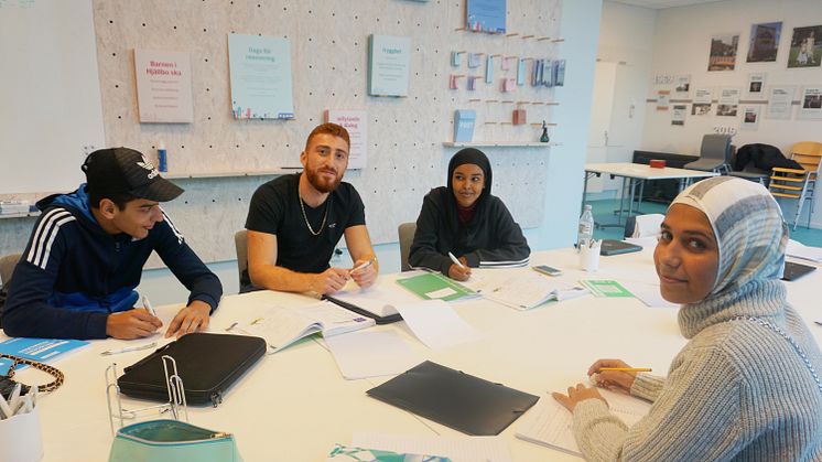 Jalal, Najma och Ritaj tillsammans med läxhjälparen Nobar i Poseidons lokal på torget i Hjällbo.