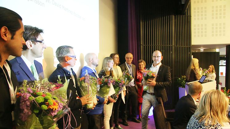 Johan Lindholm, ordförande i Riksbyggen, delar ut blommor till stipendiaterna.