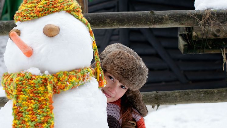 Junge Frau mit Fellmütze hinter Schneemann.jpg