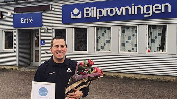 Christoffer Lindberg som är besiktningstekniker på Bilprovningen i Uppsala-Fyrislund firas med diplom och blommor eftersom han utsetts till månadens medarbetare i företaget.