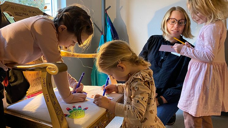 Alice och Elvira målar med stor noggrannhet sina handavtryck medan Allis berättar om sina drömmar för förskollärare Maria. 