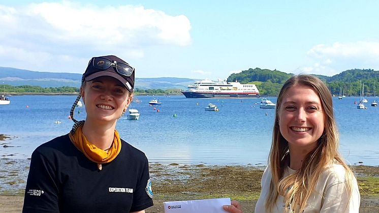 Vivi Bolin, Science & Education Coordinator on board MS Maud, presents Caroline with the donation_Credit_Hebridean Whale and Dolphin Trust