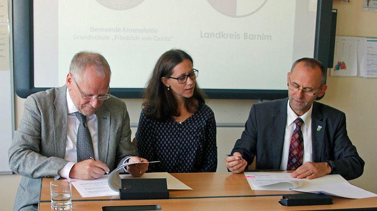 Unter den Augen von Schulleiterin Patricia Franke unterzeichnen Landrat Bodo Ihrke (l.) und Bürgermeister Wilfried Gehrke die Vereinbarung. Foto: Oliver Köhler