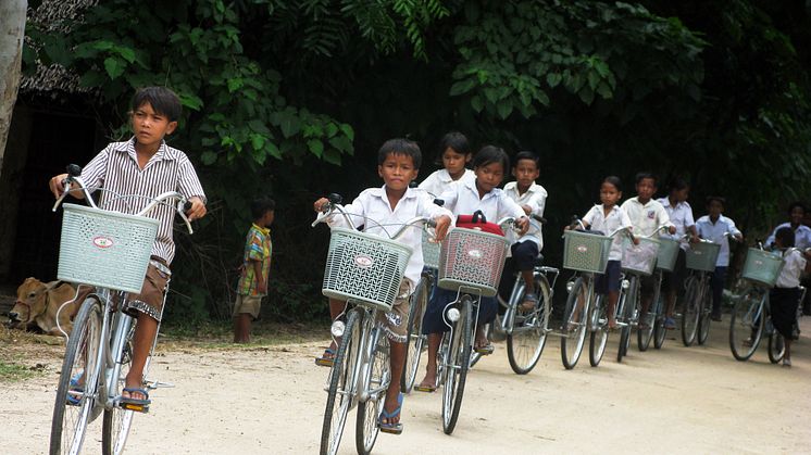 Kambodjanska skolbarn på cykel