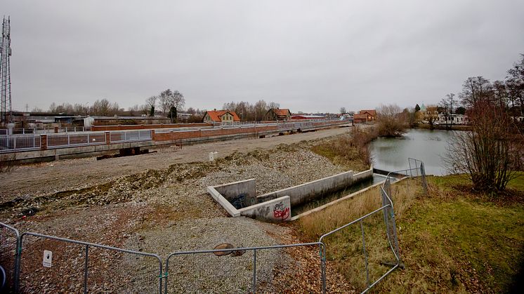 Stationsområdets östra sida i Åkarp med dammen och det gamla stationshuset i bakgrunden.