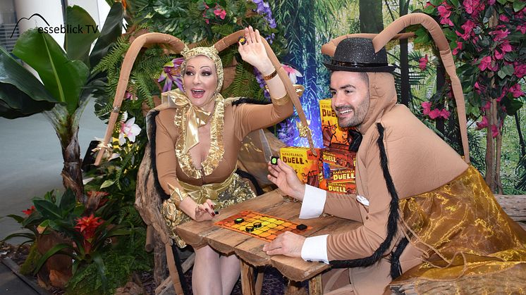 Désirée Nick & Menderes Bagci spielen Kakerlaken Duell am Stand von Schmidt Spiele