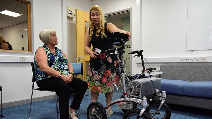 Volunteer Pauline being shown how to use the robotic walker by researcher Mia Campbell from Northumbria's PaCT Lab