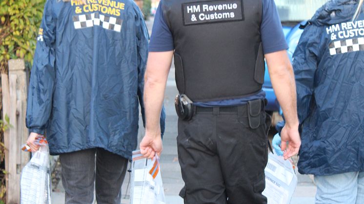 HMRC officers with seized evidence, following a coordinated operation across England into large-scale tax repayment fraud