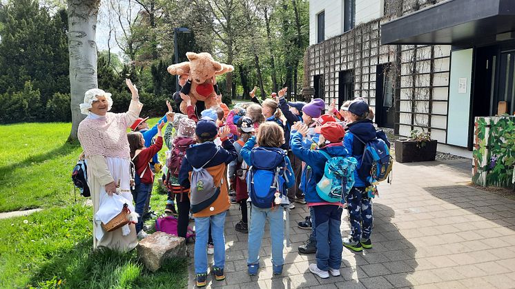 Erstklässler des Evangelischen Schulzentrums übergeben symbolisch, zusammen mit "Frau Holle", die Spende an unseren Bären 