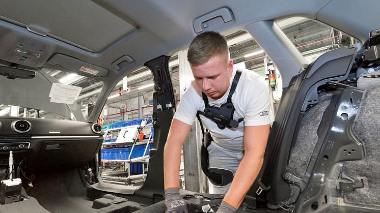 An Audi employee wears the exoskeleton to relieve the back muscles when installing the interior trim during A4 and A5 assembly at the Ingolstadt plant