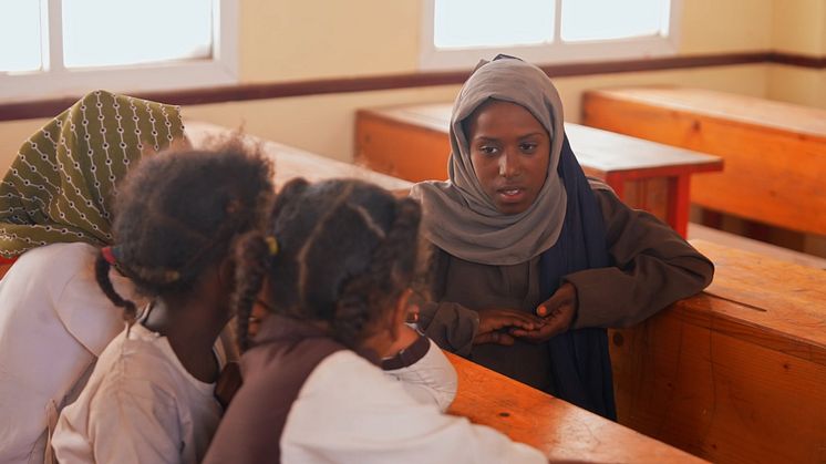 Tre nioåriga flickor med sin lärare i ett klassrum i Jemen, 2024. I skolan får eleverna inte bara undervisning utan också hjälp att bearbeta svår upplevelser från kriget. Foto: Rädda Barnen