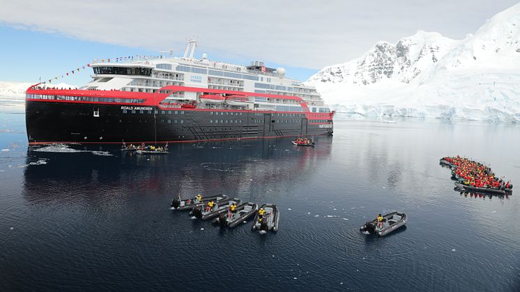 Den traditionelle flaske kølig champagne var udskiftet med en isklump, da gudmoder og ekspedisjonsleder Karin Strand gentog et ritual, der blev indført af polarhelten Roald Amundsen selv. FOTO: Shayne McGuire/Hurtigruten