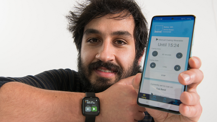 Senior Research Assistant Luís Carvalho pictured wearing the Cue Band, with the accompanying app displayed on his phone