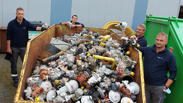 Das Ergebnis allein eines Arbeitstages im Überflutungsgebiet: ein Container voll mit Reglern, Zählern, Rohren. (v. l.) Mario Tölle (Bad Wünnenberg), Sascha Stümmler (Delbrück), Andreas Wigge (Bad Wünnenberg) und Matthias Göhre (Lage).