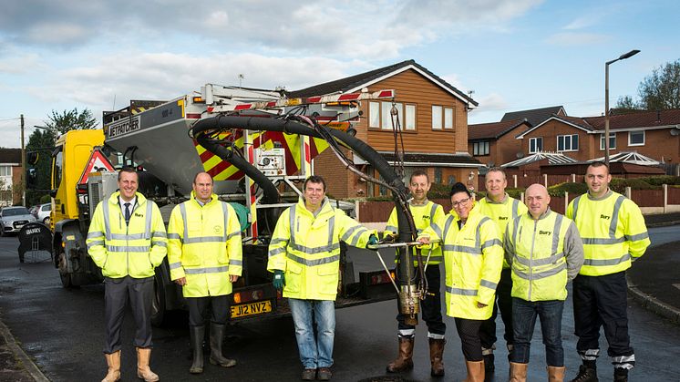 Cllr Alan Quinn and interim chief executive Pat Jones-Greenhalgh (centre) join the highways team with the kind of spray injection patching machine the council is now buying. 