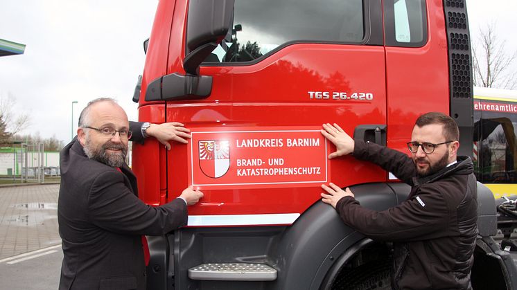 Barnims Landrat Daniel Kurth (l.) und BDG-Geschäftsführer Christian Mehnert bei der Übergabe des neuen Wechselladers. Foto: Pressestelle LK Barnim/Oliver Köhler