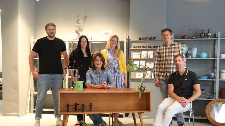 Das Team des Kleinen Kieler Kaufhaus ECHT.GUT freut sich über die Unterstützung von Janine Streu, Ansiedlungsmanagerin bei Kiel-Marketing (stehend, gelbe Jacke)