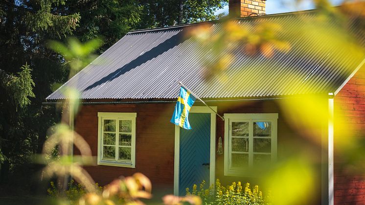 Röd stuga med Sverigeflagga