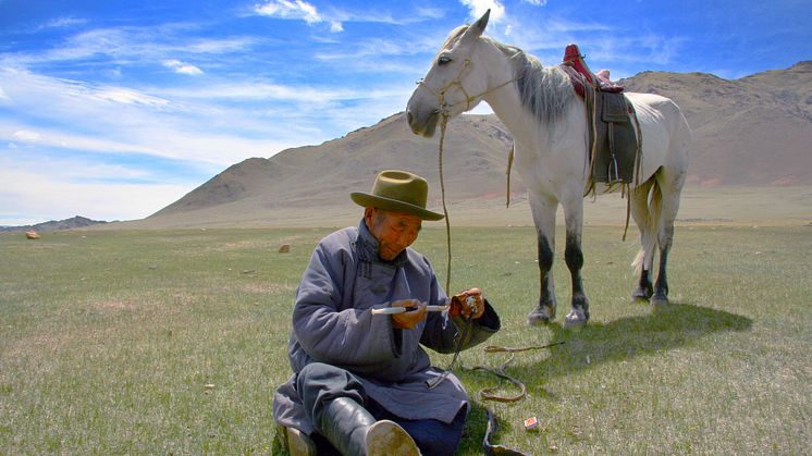 Hästburen herde med pipa, Kovd Aimag, i västra Mongoliet.