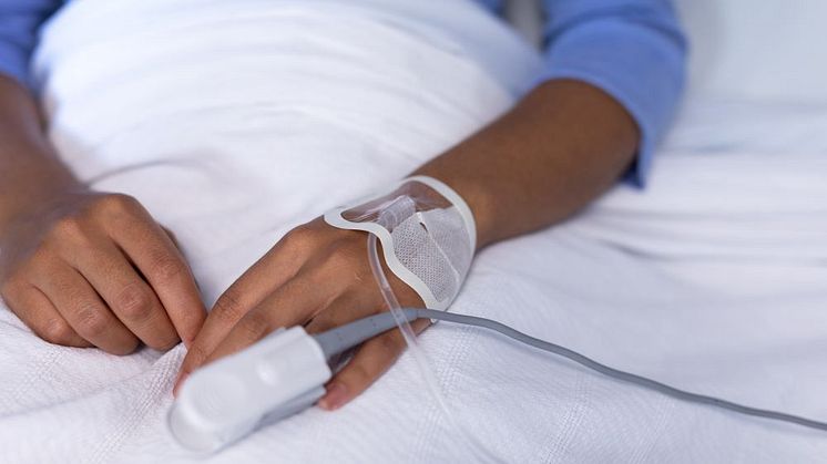 Syntolkning: Patient ligger i sjukhussäng