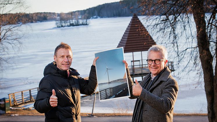 Jens Isemo och Bengt Storbacka med en visionsbild av det 150 meter höga vindkraftverket på Trallingen. Foto: Linde energi (bilden är ett montage)