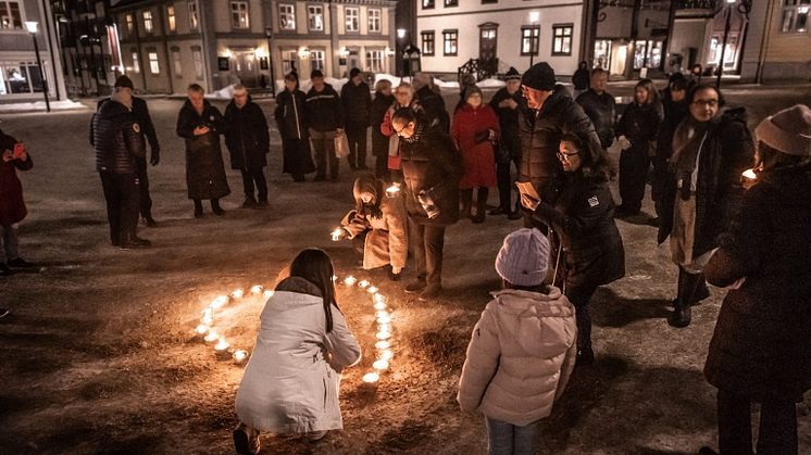 Människor samlade för att tända ljus på Piteå torg i samband med en tidigare minnesdag. Foto: Fond och Fond