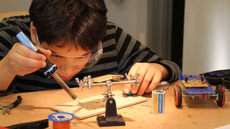 Koncentrerad kille som går kursen robotbygge hos Studiefrämjandet