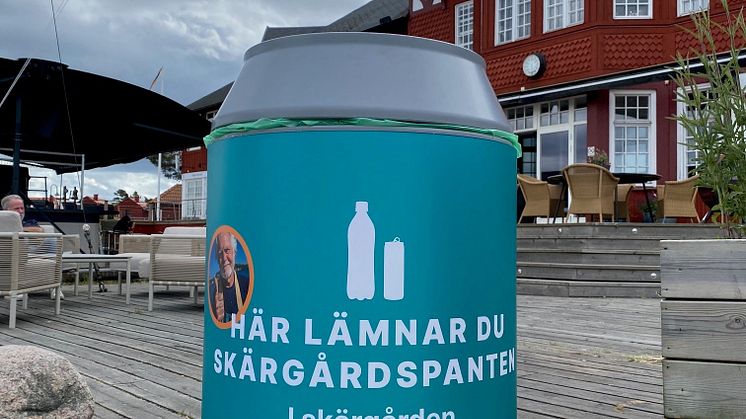 Bild på pantkärl framför ett rött hus