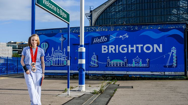 Bly Twomey poses by the new 'Welcome to Blyton' sign in Brighton 