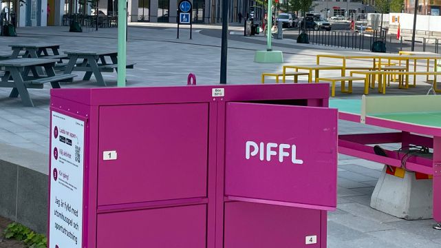 En rosa Pifflbox är placerad i Järfälla på ett torg.Aktivitetsboxen integreras i en trygg och tillgänglig stadsdelsmiljö.