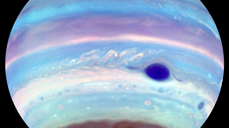 An artificially colored view of Jupiter observed in ultraviolet light. In addition to the Great Red Spot, which appears blue, another oval feature can be seen in the brown haze at Jupiter's south pole.