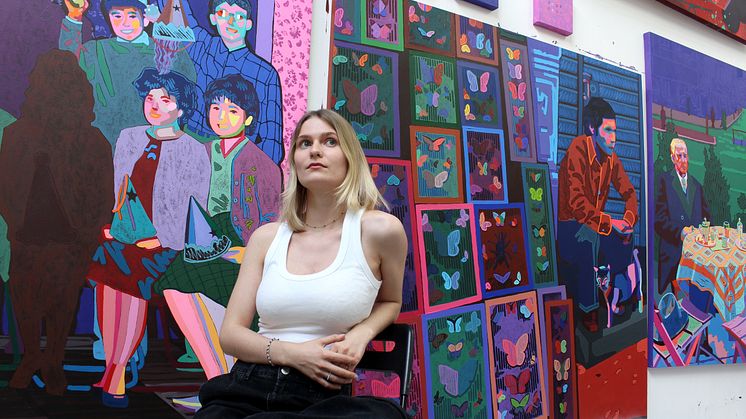 Die Künstlerin Zoe Klink vor ihren Werken, inklusive „Dead Or Alive“, eine ihrer am ARTIMA Messestand ausgestellten Arbeiten