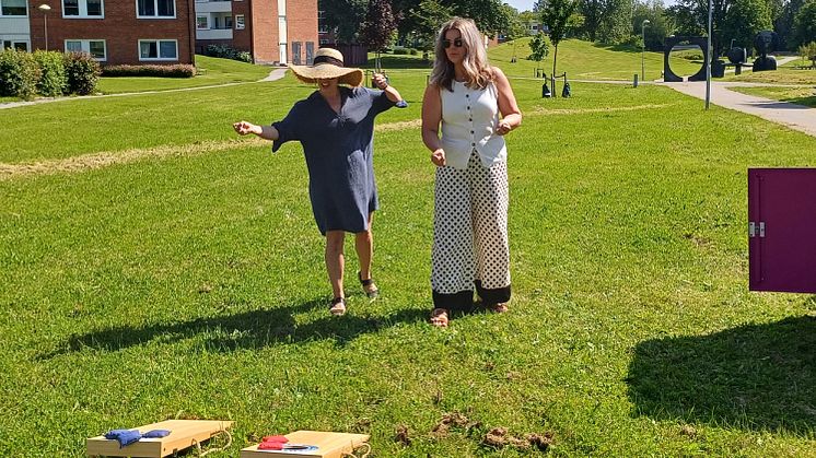 Två kvinnor spelar cornhole som de har hyrt gratis via den rosa Pifflboxen i Sundsvall.
