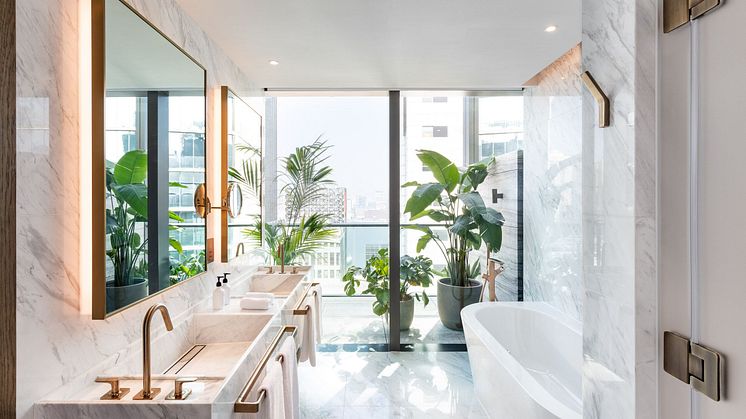 Ein luxoriöses Badezimmer mit viel Marmor, einem Doppelwaschtisch und designorientierten Armaturen von Axor