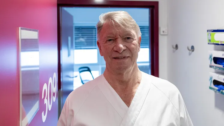 Mann med grått hår i hvite sykehusklær på et sykehus