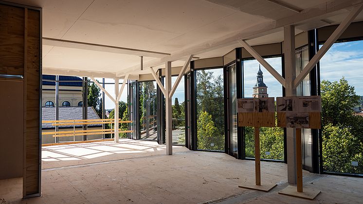 Interiör på en byggnadsarbetsplats med stora glaspartier.