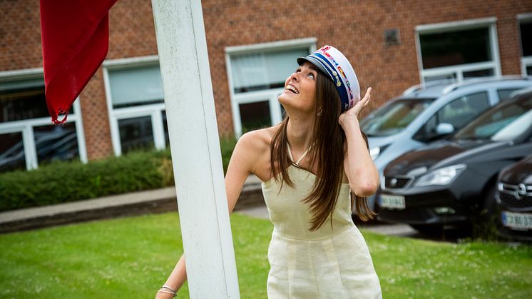 Marlene Skjerning Johansen hejser flaget foran Tradium HHX // foto: Ulrik Burhøj Jepsen