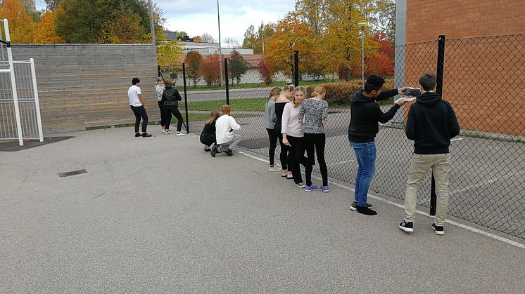 Elever på Erlaskolan i Falun mäter ute på skolgården.