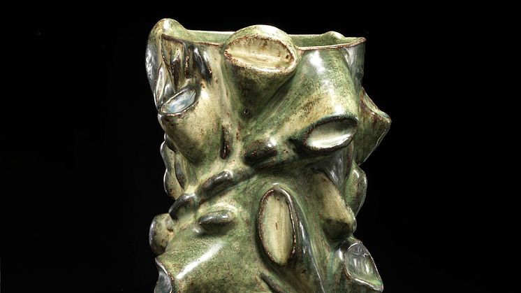 Axel Salto- Sjældent udbudt vase af stentøj modelleret med stiliserede frugter og blade i relief. H. 36,5. Diam. maks. 27.