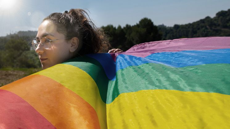kvinna haller prideflagga
