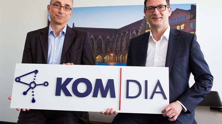 Dr. Volker Lang und Julien Mouniert mit der neuen Wort-Bild-Marke KOM│DIA