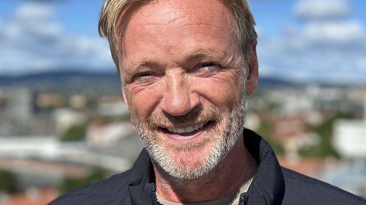 Bilde av Rune Storm, en mann i mørk jakke med bylandskap i uskarp bakgrunn. 