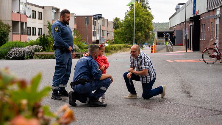 Två ordningsvakter pratar med en flicka och en man i Fittja