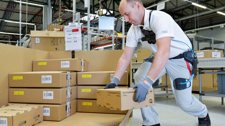 An Audi employee uses the exoskeleton when packing car components in CKD (completely knocked down) logistics at the Ingolstadt plant