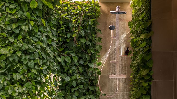 Eine Dusche mit Kopfbrause in einem Badezimmer mit vielen, grünen Pflanzen von Ideal Standard.
