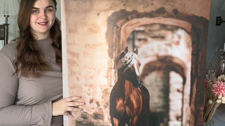 Hästfotograf Jenna Vainionpää med det fotografi hon bidrar med till välgörenhetsauktionen.