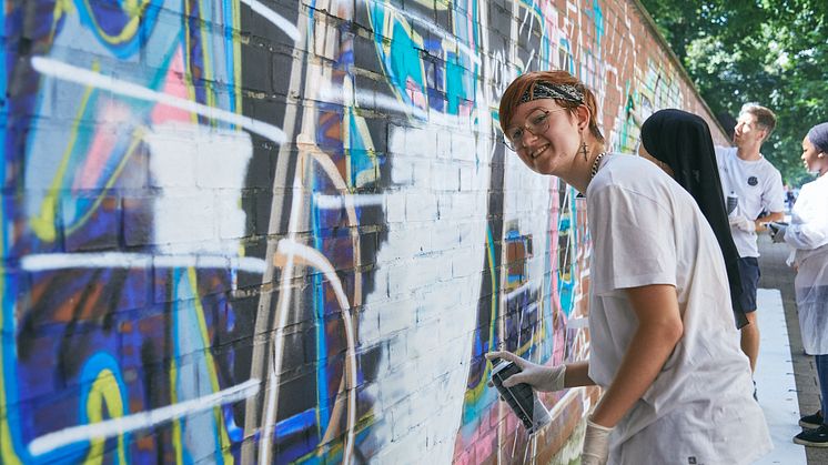 17 Jugendliche sprayten unter professioneller Anleitung "SCHÖN, DASS ES DICH GIBT" auf eine Mauer in der Münchner Schmellerstraße